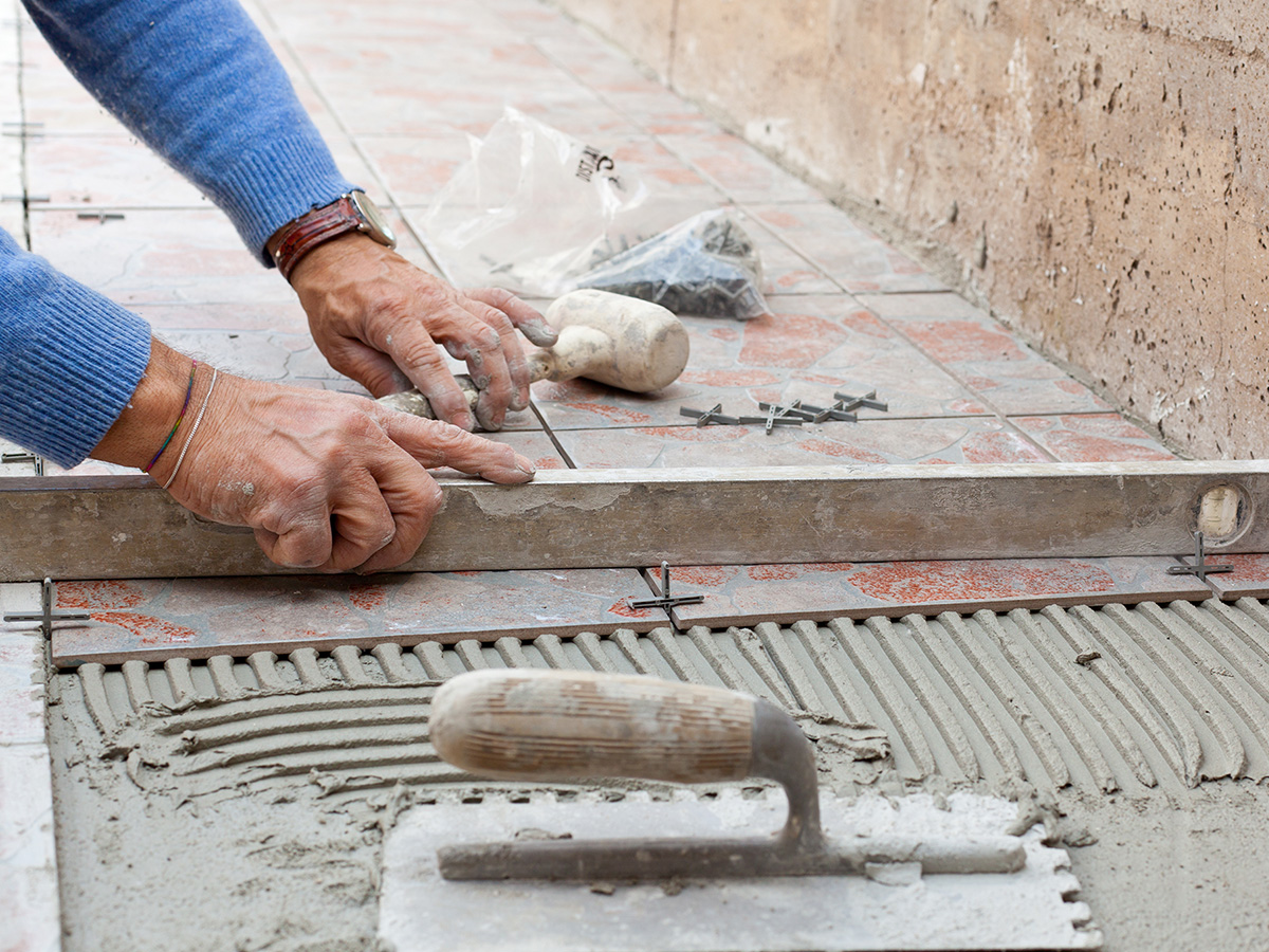 Image of a man laying tile outdoors